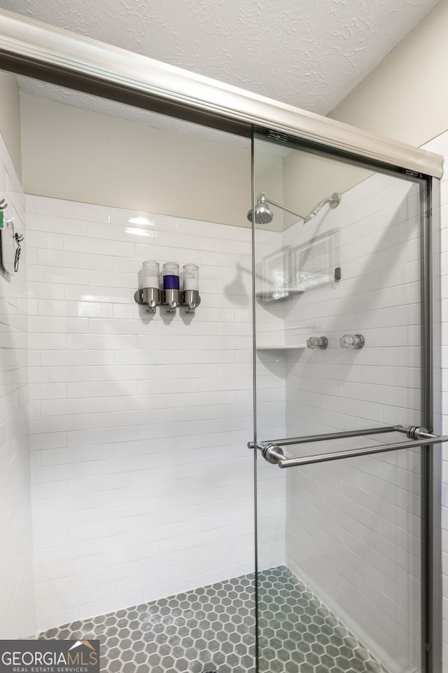 bathroom with a textured ceiling and walk in shower