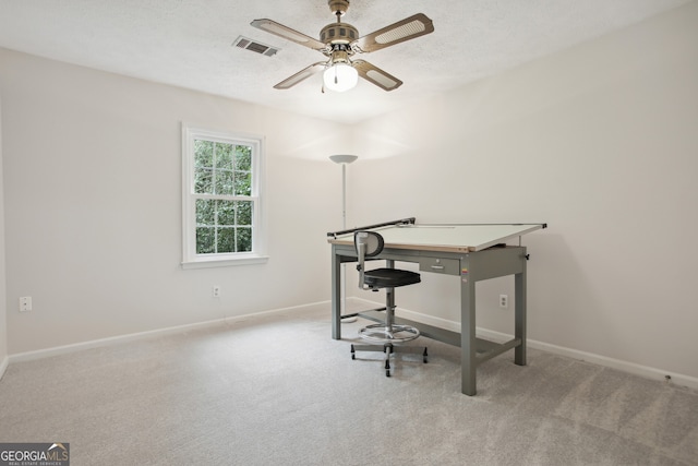 office with a textured ceiling, ceiling fan, and light carpet