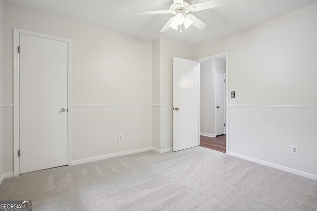 unfurnished bedroom featuring ceiling fan and light colored carpet