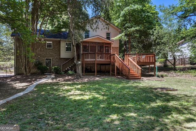 rear view of property featuring a sunroom, a yard, and a deck