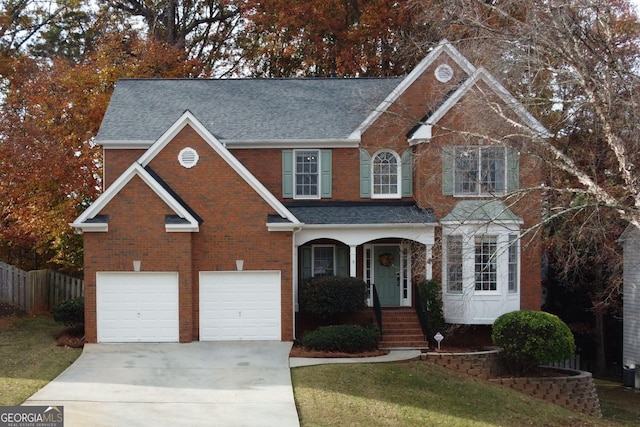 view of front property featuring covered porch, a garage, and a front lawn