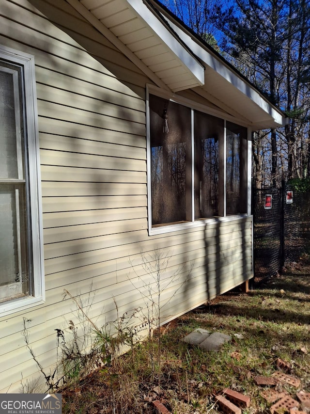 view of property exterior with a sunroom