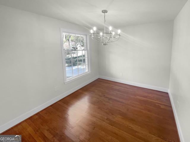 unfurnished dining area with a chandelier and dark hardwood / wood-style floors