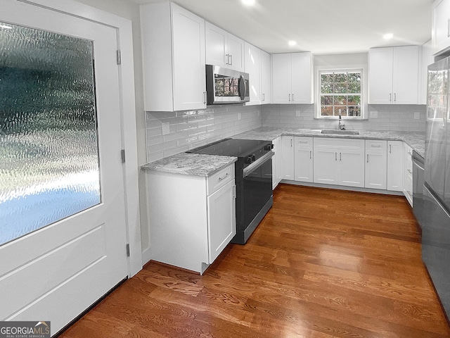 kitchen with white cabinets, dark hardwood / wood-style flooring, stainless steel appliances, and sink