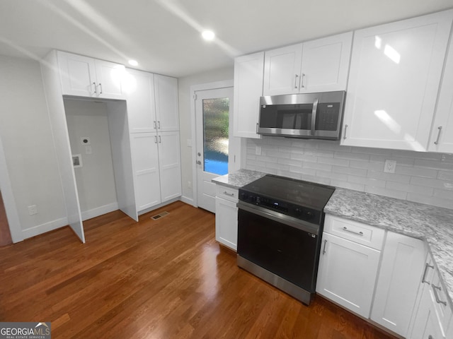 kitchen with white cabinets, dark hardwood / wood-style flooring, light stone countertops, and stainless steel appliances