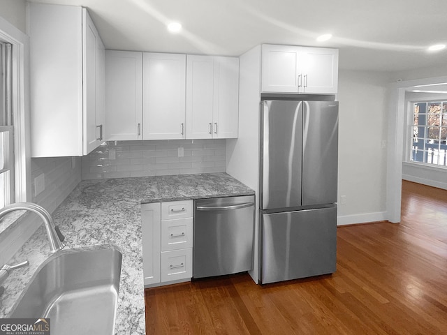 kitchen with stainless steel appliances, white cabinetry, dark wood-type flooring, and sink