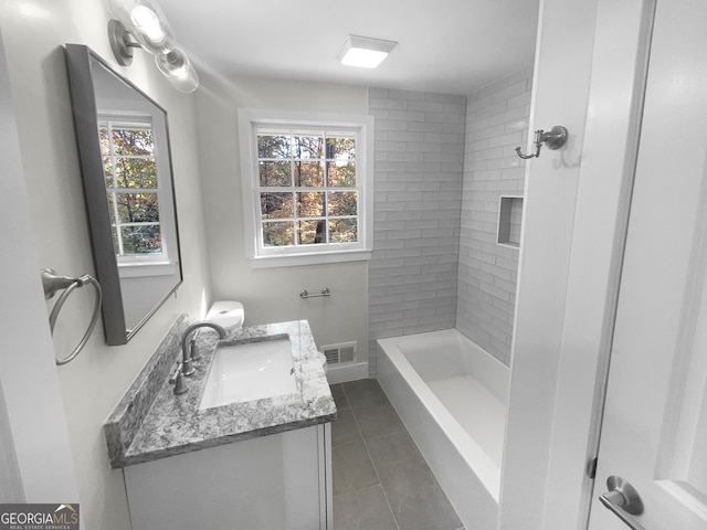 bathroom featuring tile patterned flooring, a tile shower, vanity, and a healthy amount of sunlight