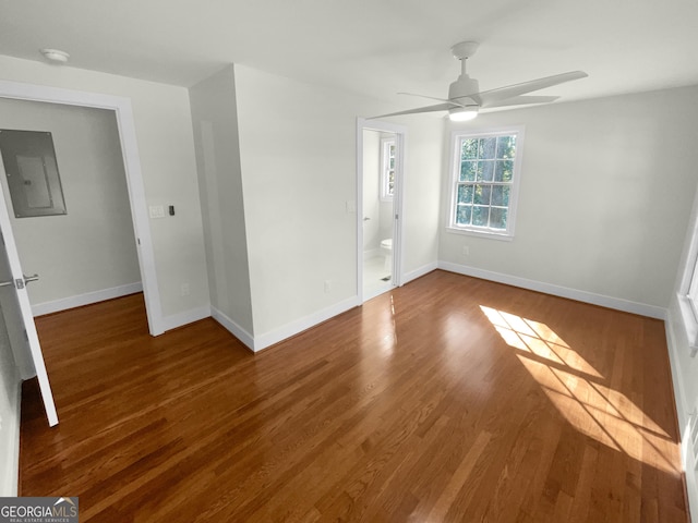 empty room featuring hardwood / wood-style flooring, ceiling fan, and electric panel