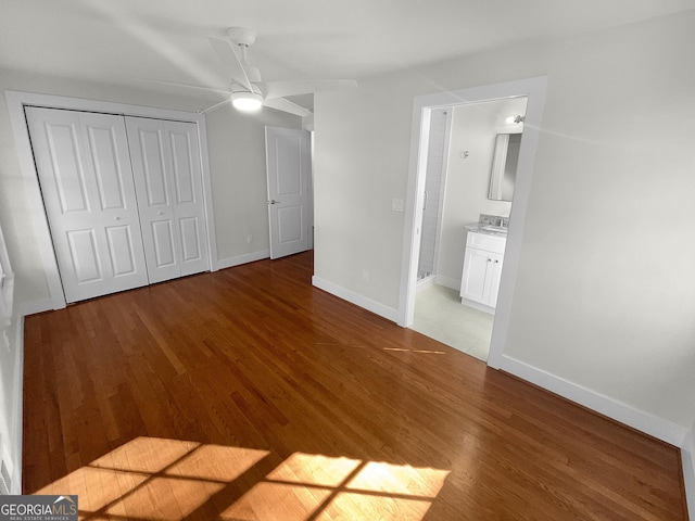 unfurnished bedroom with hardwood / wood-style floors, a closet, ceiling fan, and ensuite bathroom