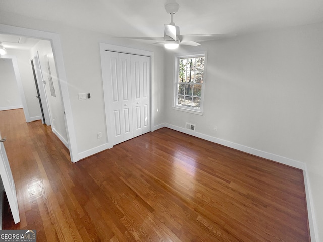 unfurnished bedroom featuring ceiling fan, a closet, and wood-type flooring