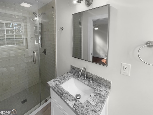 bathroom with vanity and a shower with shower door