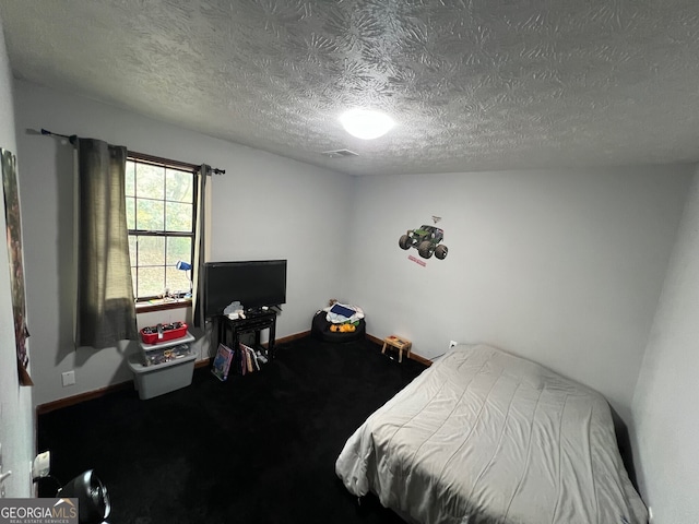 carpeted bedroom featuring visible vents, baseboards, and a textured ceiling