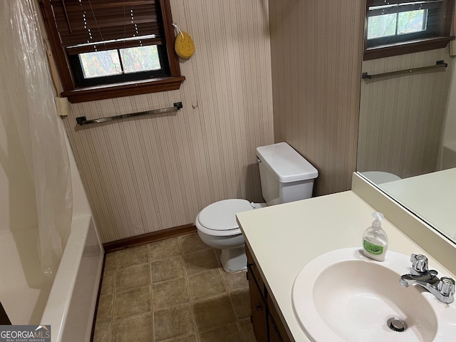 bathroom featuring baseboards, shower / bathtub combination with curtain, toilet, and wallpapered walls