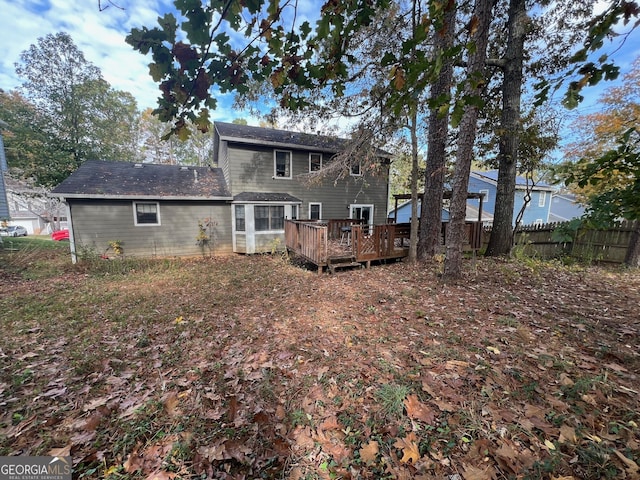 back of house featuring fence and a wooden deck