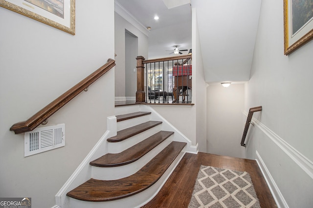 stairway with wood-type flooring and ceiling fan