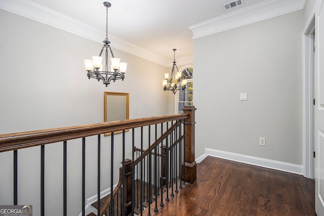 hall featuring an inviting chandelier, crown molding, and dark wood-type flooring