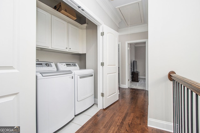 laundry area with washer and clothes dryer, crown molding, dark hardwood / wood-style flooring, and cabinets