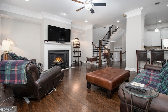 living room featuring dark hardwood / wood-style floors, ceiling fan, and crown molding