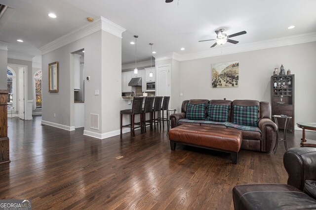 carpeted bedroom featuring ceiling fan, ornamental molding, connected bathroom, and a tray ceiling