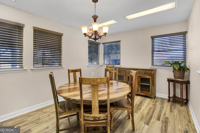 dining area featuring light wood-type flooring and a notable chandelier