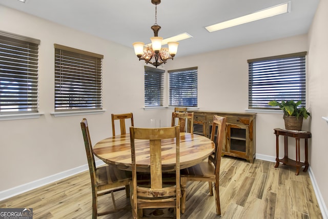 dining area with a notable chandelier, baseboards, and wood finished floors