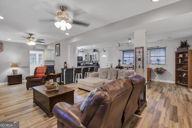 living room with a ceiling fan, light wood-type flooring, baseboards, and recessed lighting