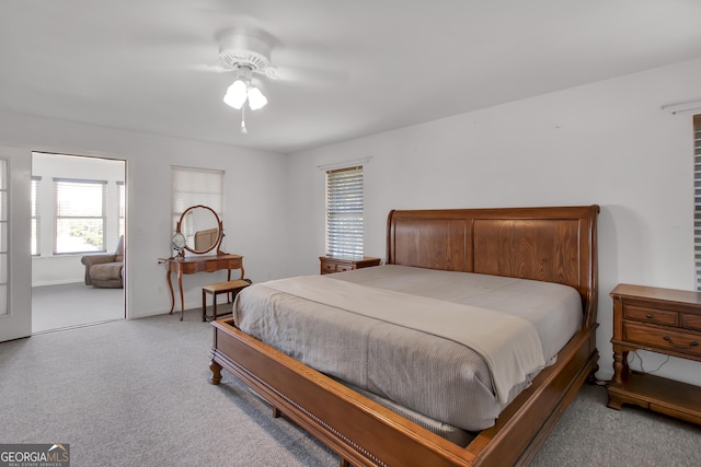 bedroom with multiple windows, ceiling fan, and light colored carpet