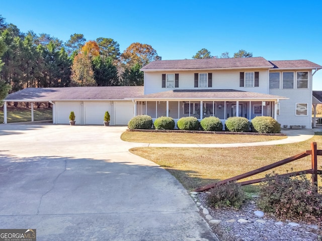 view of front of home with a garage, concrete driveway, a front lawn, and covered porch