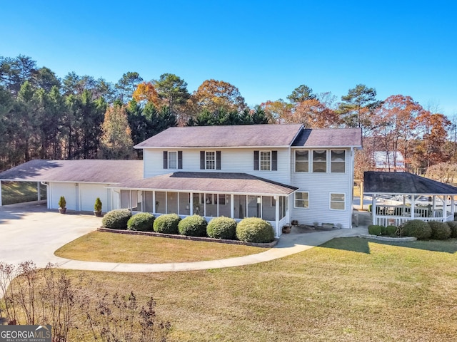 view of front of home featuring a sunroom, a garage, a front yard, and a carport