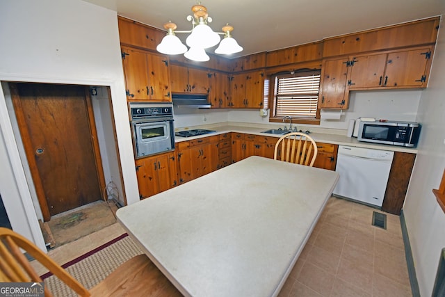 kitchen with pendant lighting, sink, stainless steel appliances, and a chandelier