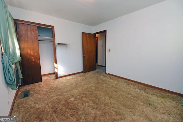 unfurnished bedroom featuring carpet flooring and a closet