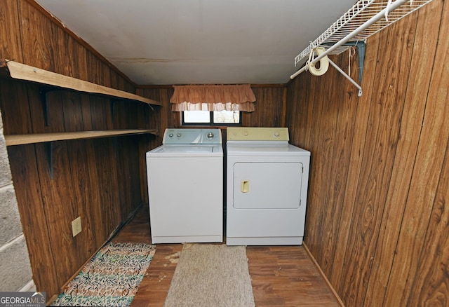 laundry room with wood walls, dark wood-type flooring, and independent washer and dryer