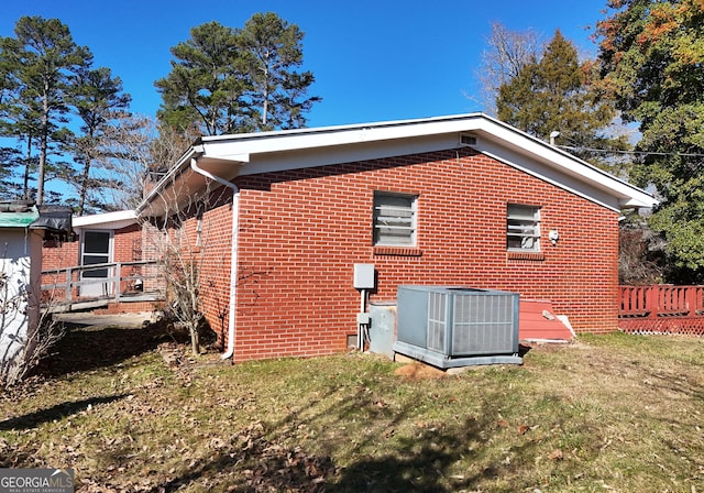 view of home's exterior with central AC unit and a lawn