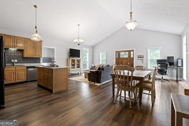 kitchen with high vaulted ceiling, dishwasher, dark hardwood / wood-style floors, and decorative light fixtures