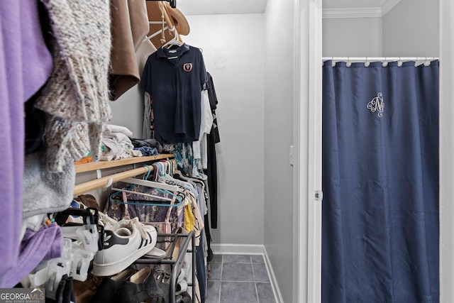 walk in closet with dark tile patterned flooring