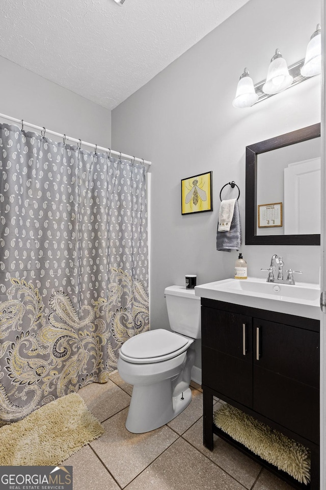 bathroom featuring vanity, toilet, and a textured ceiling