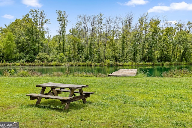 surrounding community featuring a water view and a yard