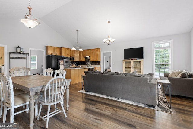 dining room featuring dark hardwood / wood-style flooring, high vaulted ceiling, and an inviting chandelier