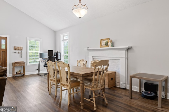 dining room featuring a fireplace, dark hardwood / wood-style floors, and high vaulted ceiling