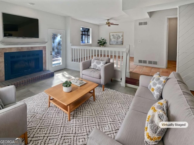 living room with a fireplace and ceiling fan