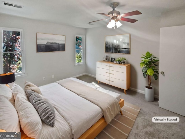 bedroom with ceiling fan, carpet floors, and multiple windows