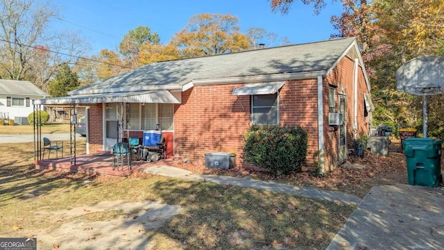 rear view of house with a yard, cooling unit, and covered porch