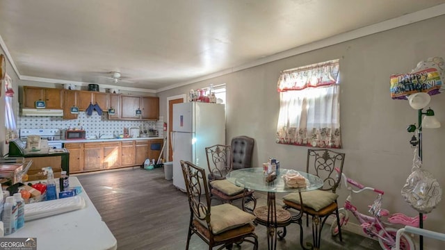 dining area featuring crown molding, dark hardwood / wood-style flooring, and ceiling fan