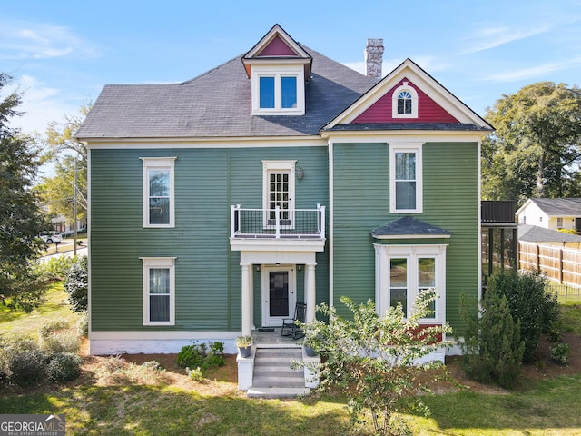 view of front facade featuring a front yard and a balcony