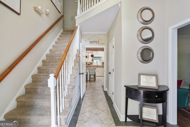 stairs with tile patterned floors and ornamental molding