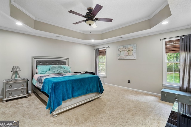 bedroom with ceiling fan, crown molding, light carpet, and a tray ceiling