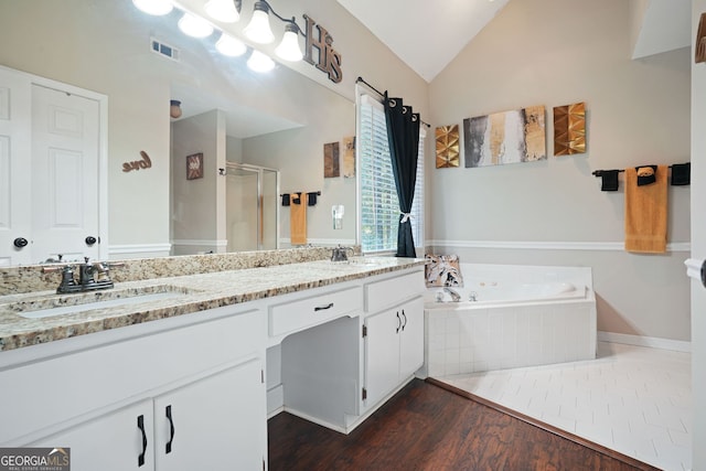 bathroom with shower with separate bathtub, vanity, vaulted ceiling, and hardwood / wood-style flooring