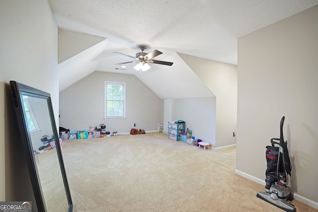 playroom with a textured ceiling, ceiling fan, lofted ceiling, and light carpet