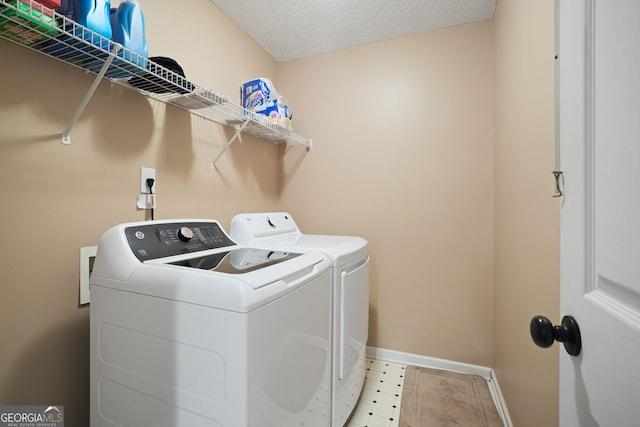 laundry area featuring separate washer and dryer and a textured ceiling