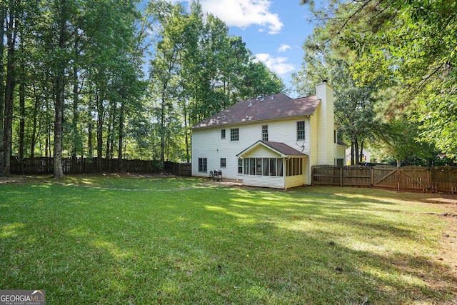 back of house with a lawn, a patio area, and a sunroom